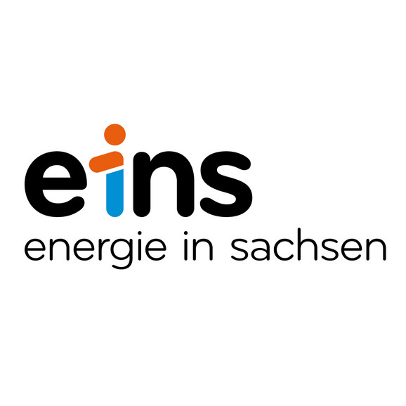 Logo von eins energie in sachsen, mit dem Wort „eins“ in Kleinbuchstaben und dem „i“ in Form einer menschlichen Figur in Orange und Blau. Unter dem Logo steht der Text „energie in sachsen“ in kleinerer Schrift. Der Hintergrund ist weiß.