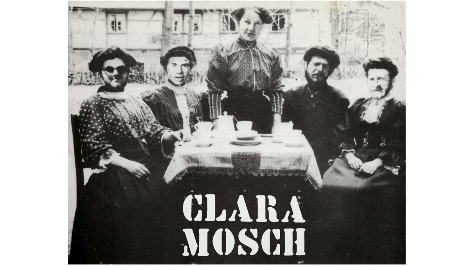 A black and white photo shows five women in old-fashioned clothes sitting around a table with teacups. The words "CLARA MOSCH" appear in bold letters at the bottom of the picture.